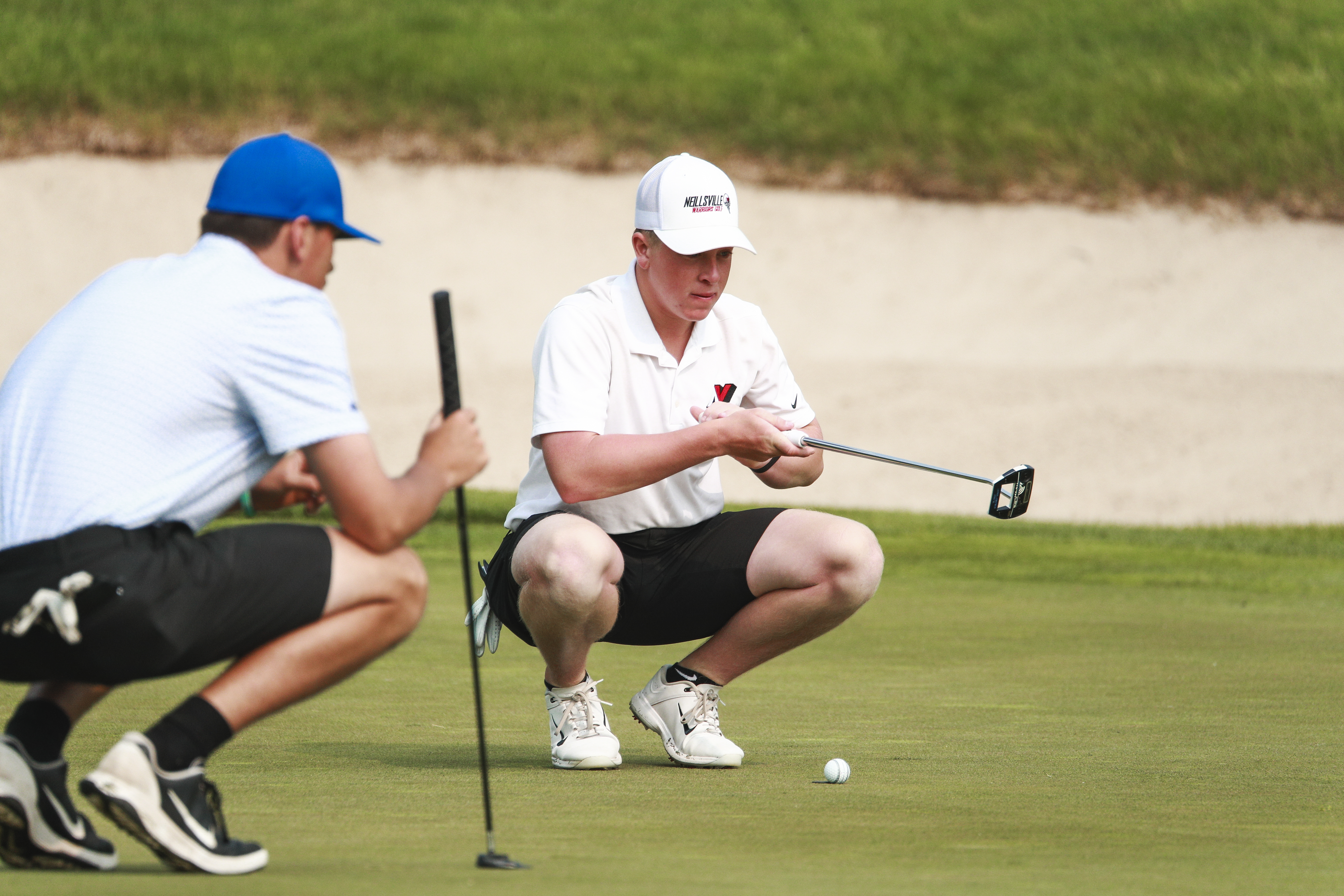 two people looking close at a golf course