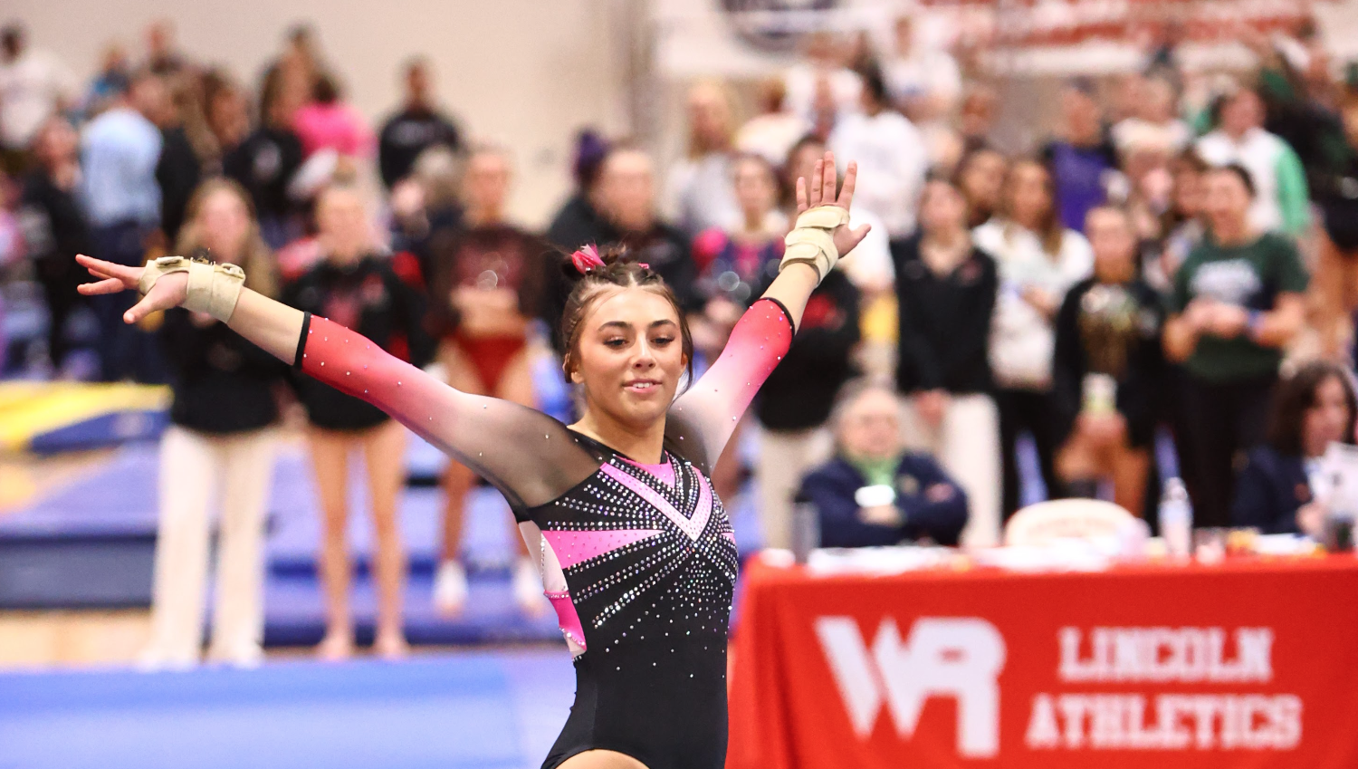 a girl poses on a gymnastics mat