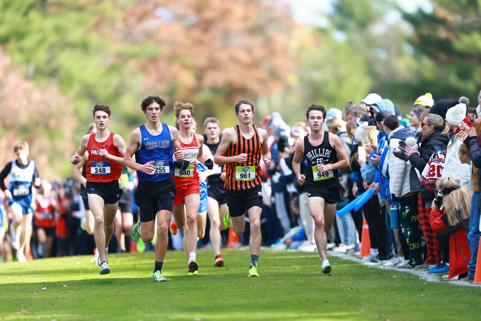 boys running cross country surrounded by a crowd