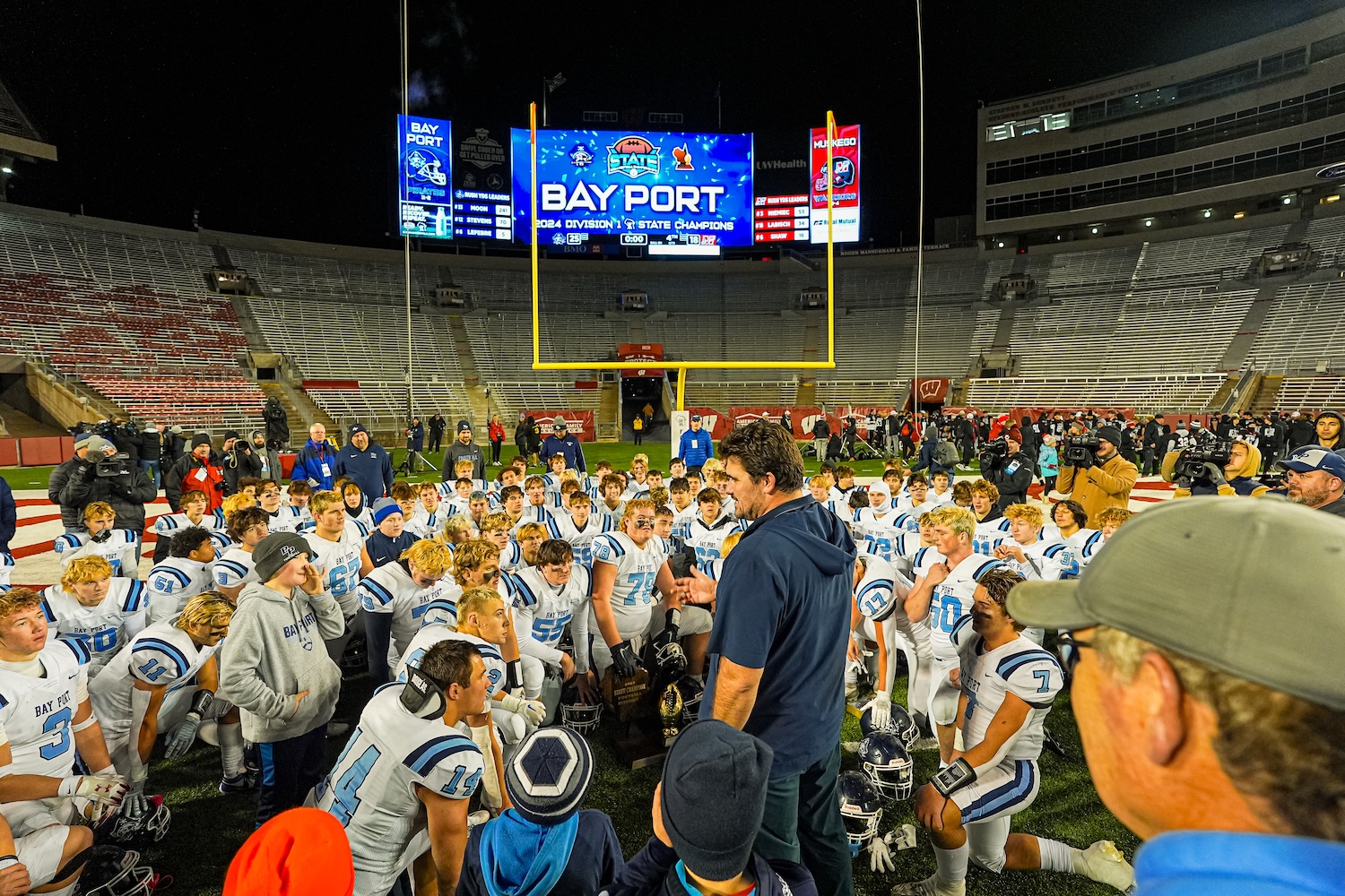 a coach is seen talking to a football team on a field 