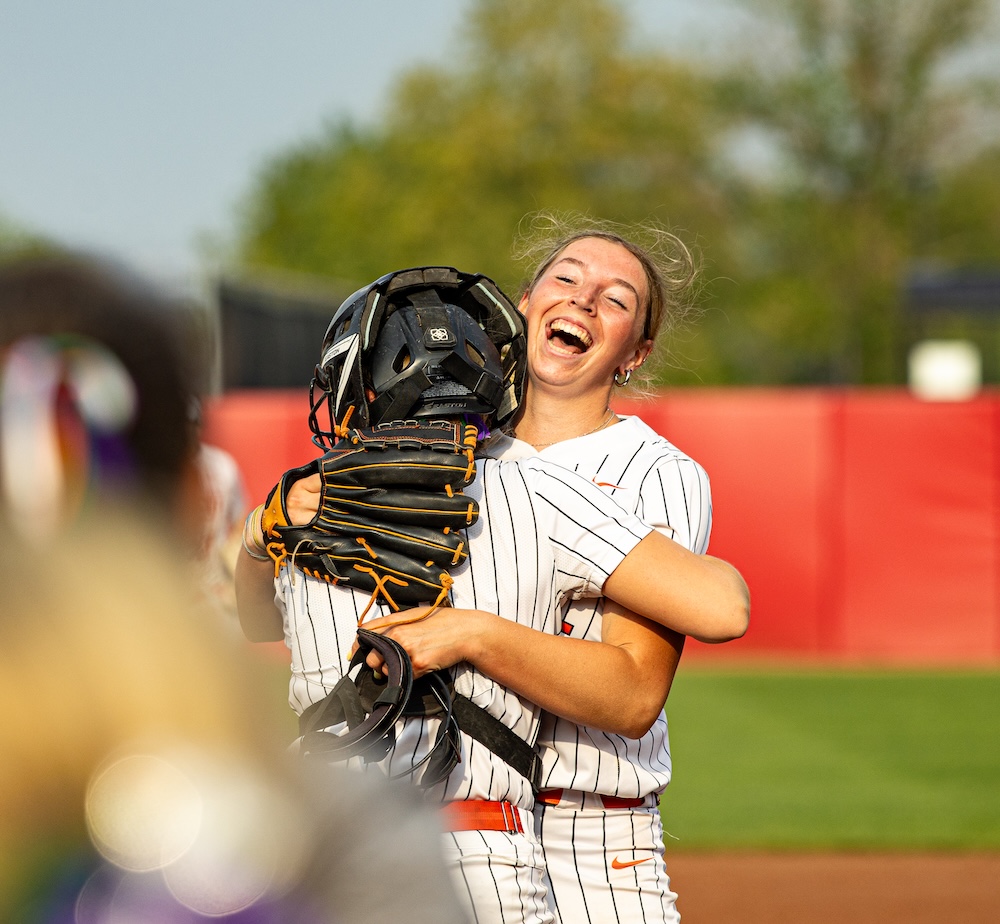 two student athletes celebrate on a field 