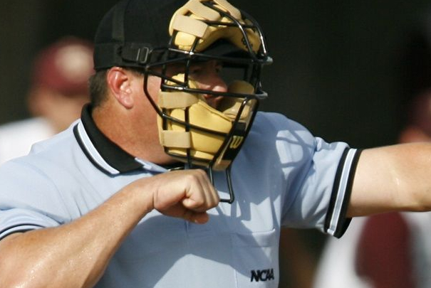 An umpire calls a strike during a high school baseball game.